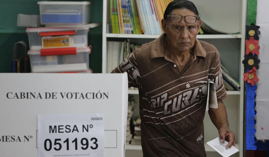 A man leaves a voting booth after voting in the congressional elections at a public school at the Villa El Salvador shantytown of Lima, Peru, Sunday, Jan. 26, 2020. Peruvians are voting to elect 130 new members of the congress that will legislate for only one year, in place of the congress that was dissolved by president Martin Vizacarra in September 2019. (AP Photo/Martin Mejia)