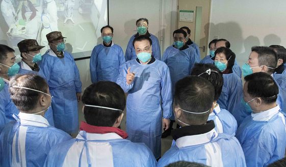 In this photo released by China&#39;s Xinhua News Agency, Chinese Premier Li Keqiang, center, speaks with medical workers at Wuhan Jinyintan Hospital in Wuhan in central China&#39;s Hubei province, Monday, Jan. 27, 2020. China on Monday expanded its sweeping efforts to contain a deadly virus, extending the Lunar New Year holiday to keep the public at home and avoid spreading infection. (Li Tao/Xinhua via AP)