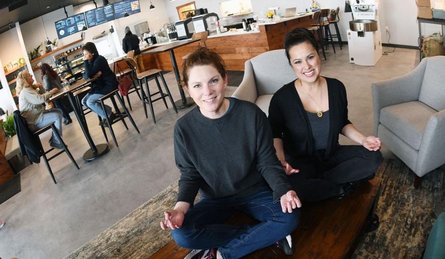 In this Jan. 10, 2020 photo, Balancing Goat Coffee Co. co-owners Karen Schmidt, left, and Dawn Hager poose in their specialty coffee, pastries, fresh fruit, smoothies, sandwiches and wellness studio at a strip mall in Mandan, N.D. (Mike McCleary/The Bismarck Tribune via AP)