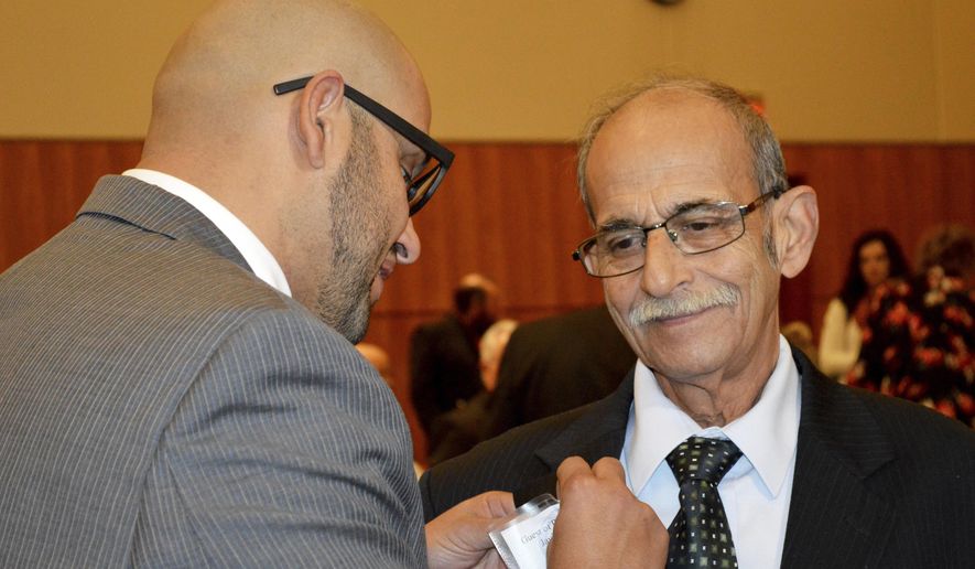 State Rep. Javier Martínez, D-Albuquerque, pins a badge of his father, Javier Martínez, Sr., of Juarez, Mexico, before the start of the New Mexico legislative session in Santa Fe, N.M. on Tuesday, Jan. 21, 2020. New Mexico's Democrat-led Legislature is looking for new ways to bolster a lagging public education system and open up new economic opportunities by legalizing recreational marijuana and providing tuition-free college education, as a 30-day legislative session began Tuesday. (AP Photo/ Russell Contreras)