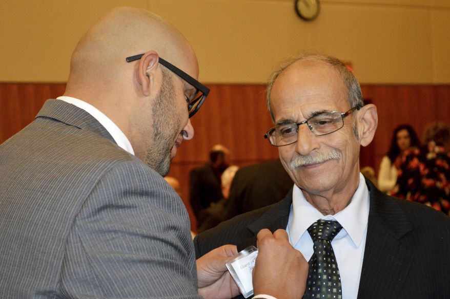 State Rep. Javier Martínez, D-Albuquerque, pins a badge of his father, Javier Martínez, Sr., of Juarez, Mexico, before the start of the New Mexico legislative session in Santa Fe, N.M. on Tuesday, Jan. 21, 2020. New Mexico's Democrat-led Legislature is looking for new ways to bolster a lagging public education system and open up new economic opportunities by legalizing recreational marijuana and providing tuition-free college education, as a 30-day legislative session began Tuesday. (AP Photo/ Russell Contreras)