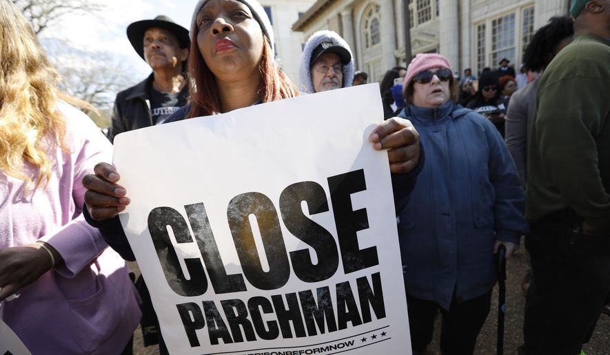 Many attendees of a rally at the Mississippi Capitol in Jackson, carried signs that protested conditions in prisons where inmates have been killed in violent clashes in recent weeks, Friday, Jan. 24, 2020. They called upon the administration to specifically close the Mississippi State Penitentiary in Parchman, where a number of deaths have occurred. (AP Photo/Rogelio V. Solis)