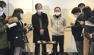 Wearing surgical masks, Takeo Aoyama, center left, and Takayuki Kato, center right, employees at Nippon Steel Corp.s subsidiary in Wuhan, China, speak to journalists after returning home by a Japanese chartered plane at Haneda international airport in Tokyo Wednesday, Jan. 29, 2020. Japan on Wednesday began evacuating their citizens from the Chinese city hardest-hit by an outbreak of a new virus. Aoyama said more than 400 Japanese people wishing to return to Japan are in Wuhan. (AP Photo/Haruka Nuga)