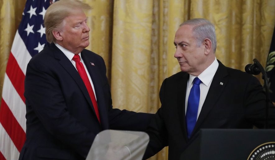 Israeli Prime Minister Benjamin Netanyahu and President Donald Trump shake hands, obscured by the top of a teleprompter, in the East Room of the White House in Washington, Tuesday, Jan. 28, 2020, to announce the Trump administration&#39;s much-anticipated plan to resolve the Israeli-Palestinian conflict. (AP Photo/Alex Brandon)