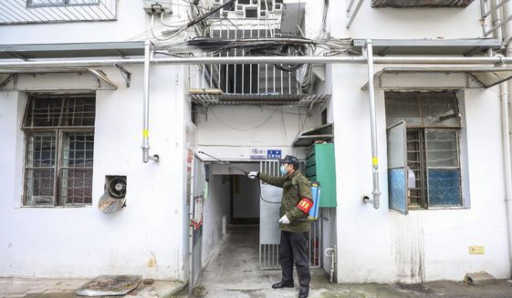 A government worker sprays disinfectant on a residential building in Wuhan in central China&#39;s Hubei Province, Tuesday, Jan. 28, 2020. Hong Kong&#39;s leader announced Tuesday that all rail links to mainland China will be cut starting Friday as fears grow about the spread of a new virus. (Chinatopix via AP)