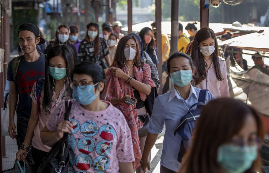 Boat passengers on a jetty wear face masks in Bangkok, Thailand, Tuesday, Jan. 28, 2020 to protect themselves from new virus infection. Panic and pollution drive the market for protective face masks, so business is booming in Asia, where fear of the coronavirus from China is straining supplies and helping make mask-wearing the new normal. (AP Photo/Gemunu Amarasinghe)