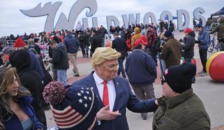Tim Carney, dressed as President Donald Trump, center, talks with people near the boardwalk before the start of a campaign rally in Wildwood, N.J., Tuesday, Jan. 28, 2020.  (AP Photo/Seth Wenig)