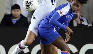 United States forward Carli Lloyd (10) and Haiti defender Soveline Beaubrun, right, collide as they go for the ball during the first half of a women&#x27;s Olympic qualifying soccer match Tuesday, Jan. 28, 2020, in Houston. (AP Photo/Michael Wyke)