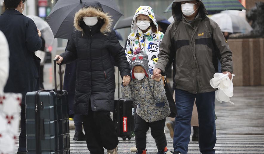 Chinese tourists wear masks at Ginza shopping district in Tokyo, Tuesday, Jan. 28, 2020. China has confirmed more than 4,500 cases of a new virus. Most have been in the central city of Wuhan where the outbreak began in December. More than 45 cases have been confirmed in other places with nearly all of them involving Chinese tourists or people who visited Wuhan recently. (AP Photo/Koji Sasahara)
