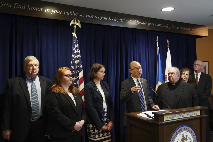 Ramsey County District Attorney Jon Choi, at podium, and Archdiocese officials hold a press conference Tuesday, Jan. 28, 2020, after the Archdiocese of St. Paul and Minneapolis submitted its final progress report on tightened clergy abuse protocols to a Ramsey County District judge at the Ramsey County Attorney's office in St. Paul, Minn. Ramsey County had sued the archdiocese in 2015 for failure to protect children, and dropped the charges in lieu of three years of court monitoring of the archdiocese. (Anthony Souffle/Star Tribune via AP)