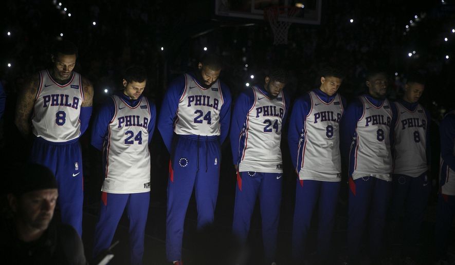 Philadelphia 76ers stand during a tribute to Kobe Bryant, before the team&#39;s NBA basketball game against the Golden State Warriors on Tuesday, Jan. 28, 2020, in Philadelphia. Bryant died along with his daughter and seven other people during helicopter crash Sunday. (Steven M. Falk/The Philadelphia Inquirer via AP)