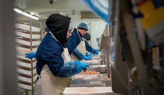 In this Tuesday, Jan. 28, 2020, photo, workers at the local fishing cooperative pack langoustines ready to be shipped to Italy, in Kilkeel harbor in Northern Ireland. (AP Photo/David Keyton) **FILE**