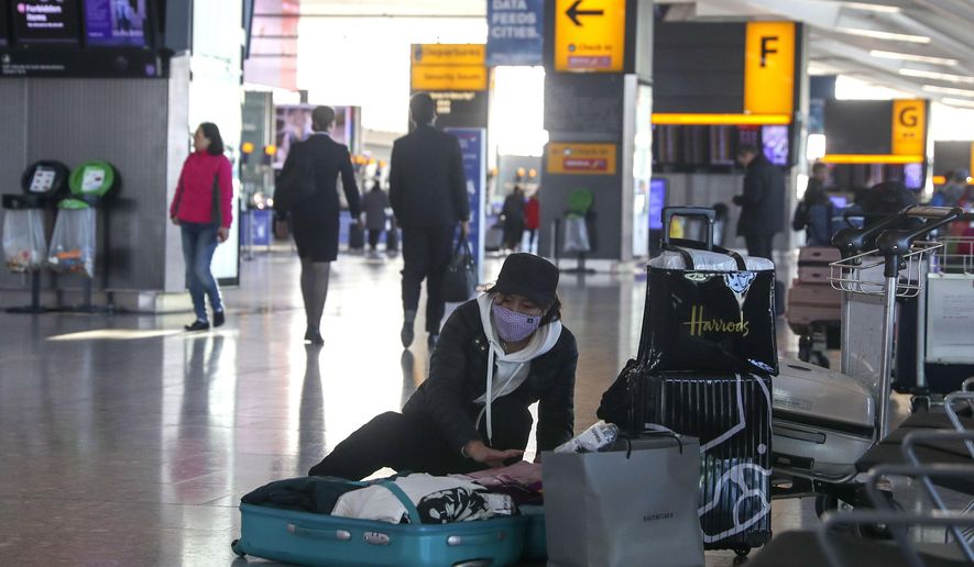 A woman wearing a face mask packs her suitcase in the departures area of Terminal 5, after it was announced British Airways has suspended all services to and from China, at London&#x27;s Heathrow Airport, Wednesday, Jan. 29, 2020. British Airways and Asian budget carriers Lion Air and Seoul Air are among the airlines suspending flights to China as fears of a new virus that has killed more than 130 people spread. Several other airlines including Finnair, Hong Kong-based Cathay Pacific and Singapore-based Jetstar Asia are reducing the number of flights to the country as demand for travel drops because of the outbreak.  (Steve Parsons/PA via AP)
