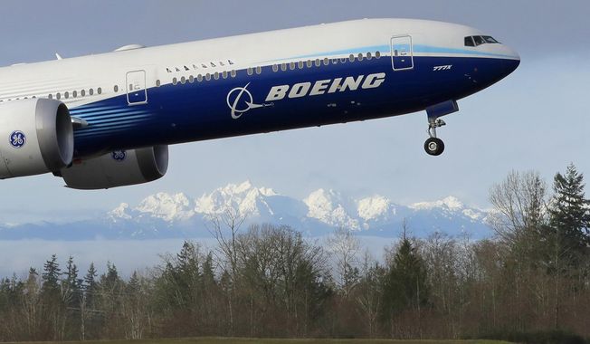 In this Jan. 25, 2020, file photo a Boeing 777X airplane takes off on its first flight with the Olympic Mountains in the background at Paine Field in Everett, Wash. Boeing Co. reports financial results on Wednesday, Jan. 29. (AP Photo/Ted S. Warren, File)  **FILE**