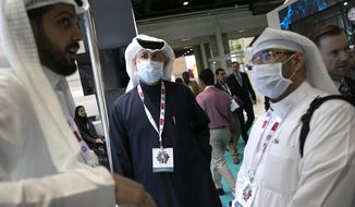 Visitors and exhibitors wear masks at the Arab Health Exhibition in Dubai, United Arab Emirates, Wednesday, Jan. 29, 2020. The United Arab Emirates on Wednesday confirmed the first cases in the Mideast of the new Chinese virus that causes flu-like symptoms, saying doctors now were treating a family that had just come from a city at the epicenter of the outbreak. (AP Photo/Kamran Jebreili)