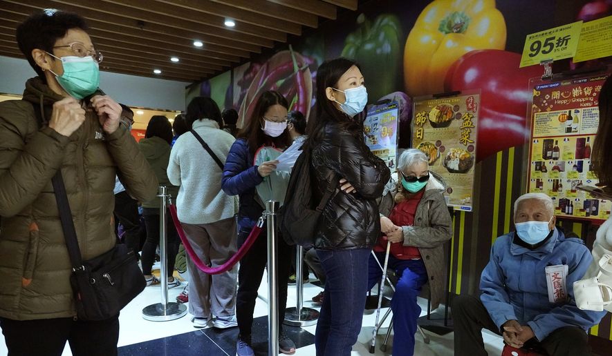 People queue up waiting to purchase face masks outside a shop in Hong Kong, Wednesday, Jan. 29, 2020. A viral outbreak that began in China has infected more than 6,000 people in the mainland and more than a dozen other countries. (AP Photo/Vincent Yu)