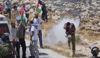 In this Aug. 16. 2019, file photo, Israeli border police disperse Palestinian, Israeli and foreign activists during a rally protesting a newly established settlement near the West Bank village of Kufr Malik, east of Ramallah. As President Donald Trump presented a Mideast plan favorable to Israel, Prime Minister Benjamin Netanyahu on Tuesday, Jan. 28, announced plans to move ahead with the potentially explosive annexation of large parts of the occupied West Bank, including dozens of Jewish settlements. (AP Photo/Nasser Nasser, File)
