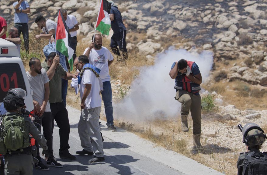 In this Aug. 16. 2019, file photo, Israeli border police disperse Palestinian, Israeli and foreign activists during a rally protesting a newly established settlement near the West Bank village of Kufr Malik, east of Ramallah. As President Donald Trump presented a Mideast plan favorable to Israel, Prime Minister Benjamin Netanyahu on Tuesday, Jan. 28, announced plans to move ahead with the potentially explosive annexation of large parts of the occupied West Bank, including dozens of Jewish settlements. (AP Photo/Nasser Nasser, File)