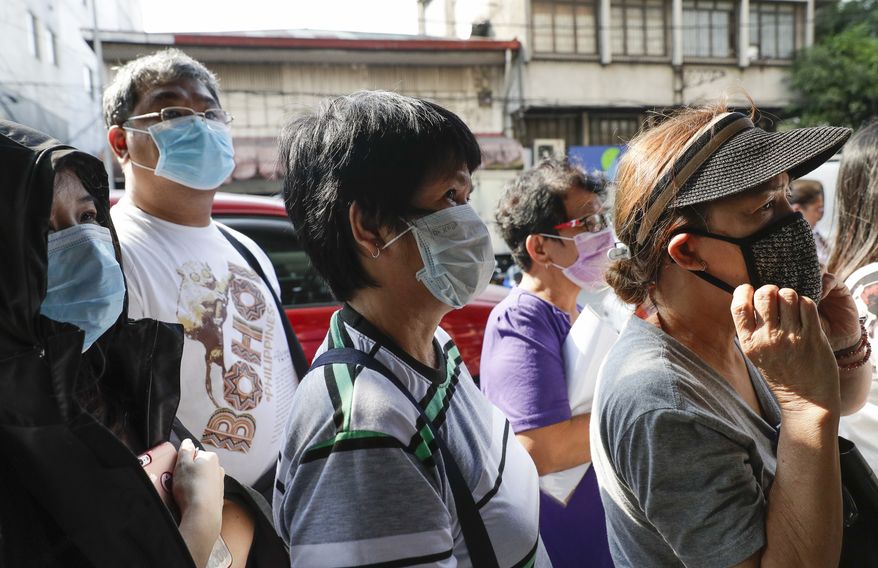People wait in line to buy protective face masks at a store in Manila, Philippines, Thursday, Jan. 30, 2020. Health Secretary Francisco Duque confirmed the Philippines' first case of the coronavirus that has infected thousands in China. (AP Photo/Aaron Favila)