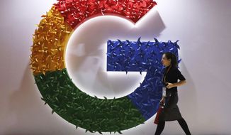 FILE - In this Monday, Nov. 5, 2018, file photo, a woman walks past the logo for Google at the China International Import Expo in Shanghai. Chinese tech giant Huawei is racing to develop replacements for Google apps. U.S. sanctions imposed on security grounds block Huawei from using YouTube and other popular Google &amp;quot;core apps.&amp;quot; (AP Photo/Ng Han Guan, File)