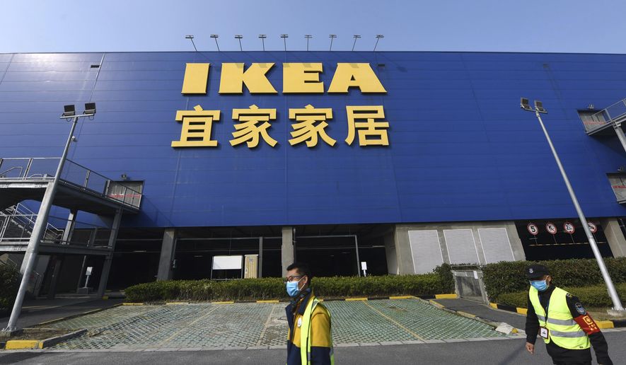 Workers walk past the entrance of a closed IKEA store in Hangzhou in eastern China&#39;s Zhejiang Province, Thursday, Jan. 30, 2020. The Swedish retailer announced then that it would temporarily shutter all of its stores in China amid a virus outbreak. (Chinatopix via AP) ** FILE **