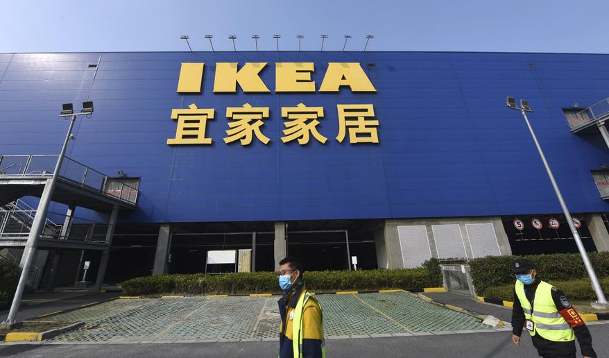 Workers walk past the entrance of a closed IKEA store in Hangzhou in eastern China's Zhejiang Province, Thursday, Jan. 30, 2020. The Swedish retailer announced then that it would temporarily shutter all of its stores in China amid a virus outbreak. (Chinatopix via AP) ** FILE **