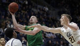 Oregon&#39;s Payton Pritchard, second from right, shoots past California&#39;s Lars Thiemann (21) in the second half of an NCAA college basketball game Thursday, Jan. 30, 2020, in Berkeley, Calif. (AP Photo/Ben Margot)