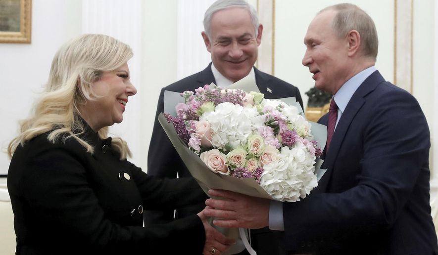 Russian President Vladimir Putin, right, greets Israeli Prime Minister Benjamin Netanyahu&#39;s wife Sara, left, as Israeli Prime Minister Benjamin Netanyahu stands at centre, prior to their talks in the Kremlin in Moscow, Russia, Thursday, Jan. 30, 2020. Netanyahu visited Moscow to discuss the U.S. Mideast peace plan with Putin and take an Israeli woman who had been jailed in Russia back home. (Maxim Shemetov/Pool Photo via AP)