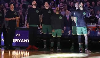 Boston Celtics players look top at a video tribute to the late Los Angeles Laker Kobe Bryant, before an NBA basketball game against the Golden State Warriors, Thursday, Jan. 30, 2020, in Boston. (AP Photo/Elise Amendola)