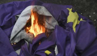 Brexit supporters burn a European Union flag in London, Friday, Jan. 31, 2020. Britain officially leaves the European Union on Friday after a debilitating political period that has bitterly divided the nation since the 2016 Brexit referendum. (AP Photo/Alberto Pezzali)