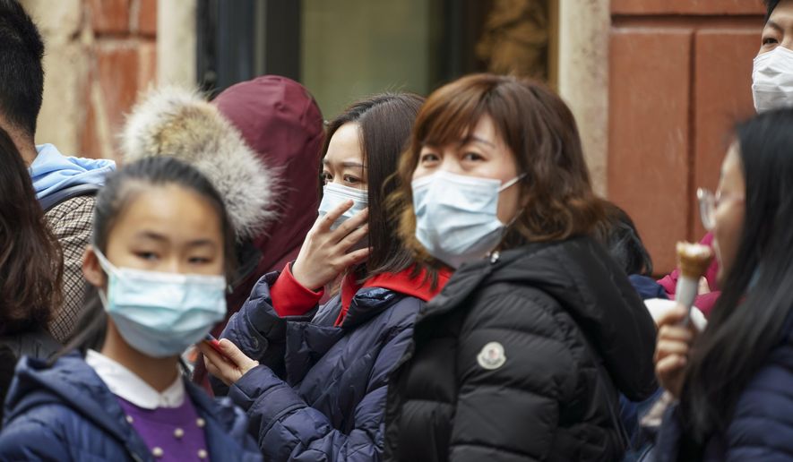 Chinese tourists wear masks in Rome, Friday, Jan. 31, 2020. Italy banned all flights coming from and going to China as European countries have stepped up their response to the new virus that has sickened thousands of people in China and reached 19 other countries. (AP Photo/Andrew Medichini)