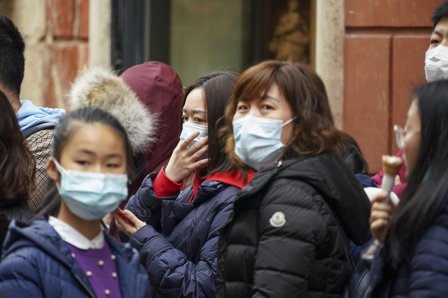 Chinese tourists wear masks in Rome, Friday, Jan. 31, 2020. Italy banned all flights coming from and going to China as European countries have stepped up their response to the new virus that has sickened thousands of people in China and reached 19 other countries. (AP Photo/Andrew Medichini)