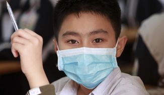 A student wears a protective face mask in during class at the Dinh Cong secondary school in Hanoi, Vietnam on Friday, Jan. 31, 2020. The authorities have advised students to wear masks to school, a day after Vietnam confirmed three more cases of the new virus. (AP Photo/Hau Dinh)