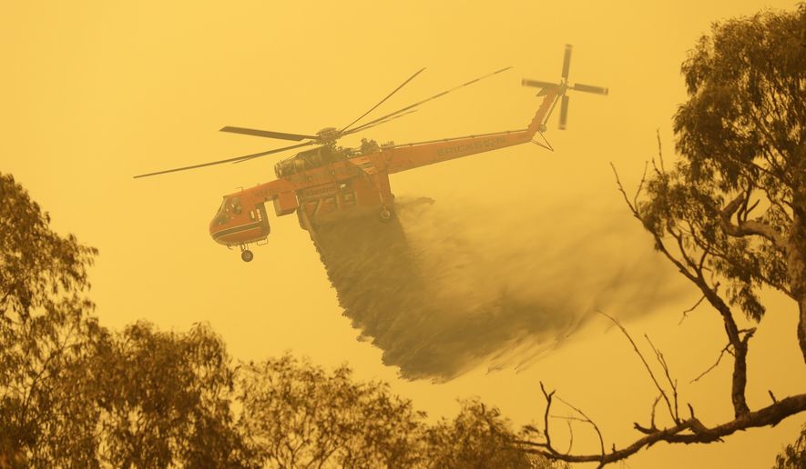 A helicopter drops water on a fire near Bumbalong, south of the Australian capital, Canberra, Saturday, Feb. 1, 2020. The threat is posed by a blaze on Canberra&#x27;s southern fringe that has razed more than 21,500 hectares (53,000 acres) since it was sparked by heat from a military helicopter landing light on Monday, the Emergency Services Agency said. (AP Photo/Rick Rycroft)