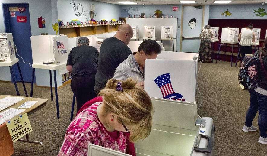 In this June 5, 2018, file photo, voters mark ballots at a polling place in the library at the Robert F. Kennedy Elementary School in Los Angeles. Californians start voting Monday, Feb. 3, 2020, in a high-profile Democratic presidential primary that has no clear front-runner. For the first time, Californians can register to vote on election day at the polls. (AP Photo/Richard Vogel, File)