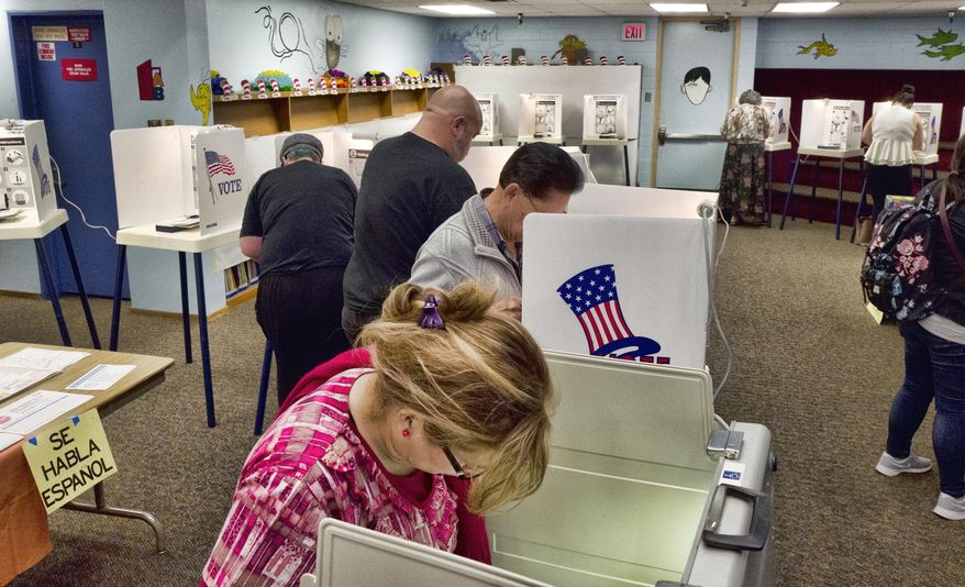 In this June 5, 2018, file photo, voters mark ballots at a polling place in the library at the Robert F. Kennedy Elementary School in Los Angeles. Californians start voting Monday, Feb. 3, 2020, in a high-profile Democratic presidential primary that has no clear front-runner. For the first time, Californians can register to vote on election day at the polls. (AP Photo/Richard Vogel, File)