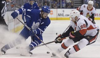 Toronto Maple Leafs centre Auston Matthews (34) and Ottawa Senators right wing Connor Brown (28) battle for the puck during second period NHL hockey action in Toronto, Saturday, Feb. 1, 2020. (Nathan Denette/The Canadian Press via AP)