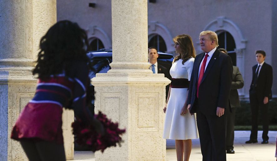 President Donald Trump and first lady Melania Trump, and their son Barron Trump, right, watch as the Florida Atlantic University Marching Band performs during a Super Bowl party at the Trump International Golf Club in West Palm Beach, Fla., Sunday, Feb. 2, 2020. (AP Photo/Susan Walsh)