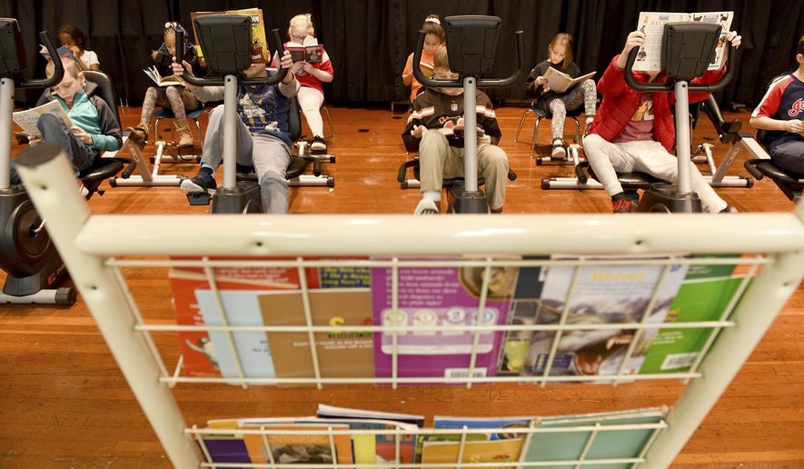 In this Monday, Jan. 13, 2020 photo, students participate in Read and Ride at Middlebranch Elementary School in Plain Township, Ohio. (Julie Vennitti/The Canton Repository via AP)