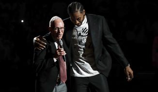 Former San Diego State forward Kawhi Leonard, right, reacts alongside former San Diego State coach Steve Fisher as Leonard&#x27;s No 15 jersey is retired during a halftime ceremony in San Diego State&#x27;s NCAA college basketball game against Utah State, Saturday, Feb. 1, 2020, in San Diego. (AP Photo/Gregory Bull)