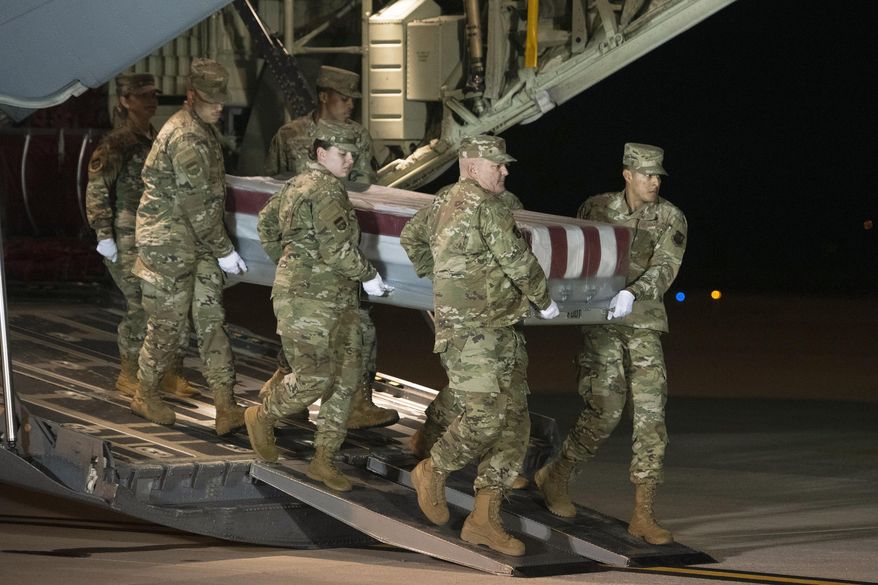 FILE - In a Dec. 8, 2019 file photo, an Air Force carry team moves a transfer case containing the remains of Navy Ensign Joshua Watson, at Dover Air Force Base, Del. Al-Qaida's branch in Yemen claimed responsibility Sunday, Feb. 2, 2020 for last year's deadly shooting at the Naval Air Station Pensacola by an aviation student from Saudi Arabia. The shooter, 2nd Lt. Mohammed Saeed Alshamrani, was a member of the Saudi Air Force in training at the base. (AP Photo/Cliff Owen, File)