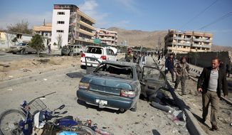 In this Wednesday, Nov. 13, 2019, file photo, Afghan security personnel gather at the site of a car bomb attack in Kabul, Afghanistan.  (AP Photo/Rahmat Gul, File) **FILE**