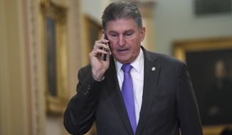 Sen. Joe Manchin, D-W.Va., talks on his phone as he walks on Capitol Hill in Washington, Monday, Feb. 3, 2020, before the continuation of the impeachment trial of President Donald Trump. (AP Photo/Susan Walsh)