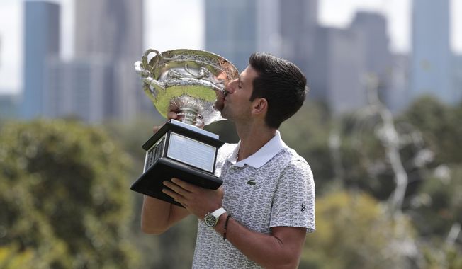 Serbia&#x27;s Novak Djokovic kisses his trophy, the Norman Brookes Challenge Cup, during a photo shoot at Melbourne&#x27;s Royal Botanic Gardens following his win over Austria&#x27;s Dominic Thiem in the men&#x27;s singles final at the Australian Open tennis championships, in Melbourne, Australia, Monday, Feb. 3, 2020. (AP Photo/Dita Alangkara)