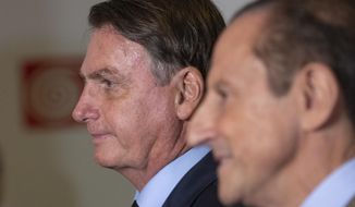 Brazilian President Jair Bolsonaro, left, and Paulo Skaf, president of the Sao Paulo&#39;s Industries Federation, FIESP, arrive for a meeting with Brazilian businessmen in Sao Paulo, Brazil, Monday, Feb. 3, 2020. (AP Photo/Andre Penner)