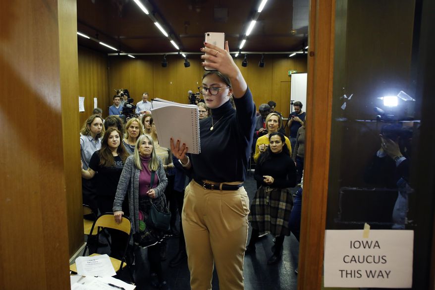 Emily Hagedorn, center, gives a phonecall to announce the election results, in Paris, Monday, Feb. 3, 2020. Paris is one of just three satellite caucus locations outside the U.S., and drew the biggest number of expat Iowans. (AP Photo/Thibault Camus)