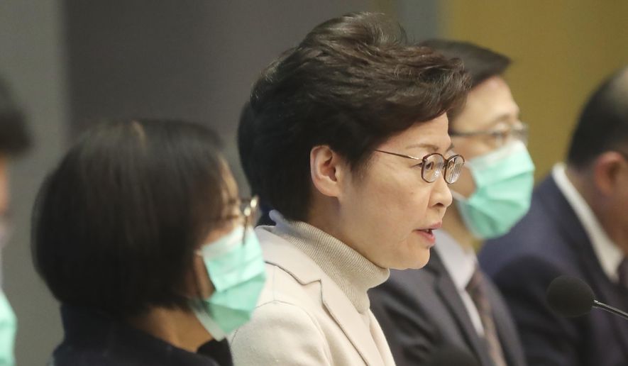 Hong Kong Chief Executive Carrie Lam, center, speaks during a press conference held in Hong Kong, Monday, Feb 3, 2020. Lam says the city will shut almost all land and sea border control points to the mainland from midnight to stem the spread of the novel coronavirus from China. (AP Photo/Achmad Ibrahim)