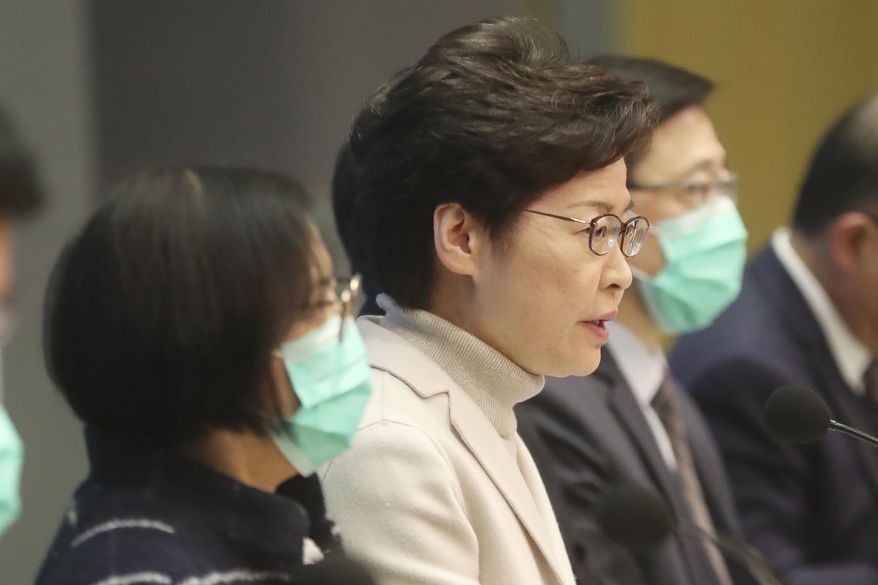 Hong Kong Chief Executive Carrie Lam, center, speaks during a press conference held in Hong Kong, Monday, Feb 3, 2020. Lam says the city will shut almost all land and sea border control points to the mainland from midnight to stem the spread of the novel coronavirus from China. (AP Photo/Achmad Ibrahim)