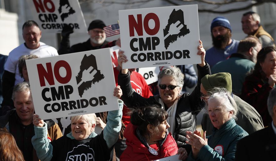 Supporters of "No CMP Corridor" attend a rally after submitting more than 75,000 signatures to election officials at the State Office Building, Monday, Feb. 3, 2020, in Augusta, Maine. Opponents of a proposed $1 billion transmission line aimed at bringing Canadian hydropower to the New England grid collected more than enough signatures to put the proposal to a statewide vote, officials said Monday. (AP Photo/Robert F. Bukaty)