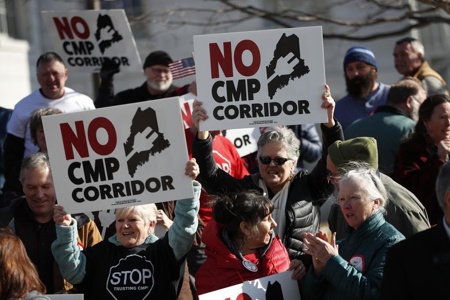 Supporters of "No CMP Corridor" attend a rally after submitting more than 75,000 signatures to election officials at the State Office Building, Monday, Feb. 3, 2020, in Augusta, Maine. Opponents of a proposed $1 billion transmission line aimed at bringing Canadian hydropower to the New England grid collected more than enough signatures to put the proposal to a statewide vote, officials said Monday. (AP Photo/Robert F. Bukaty)